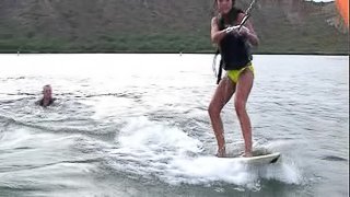 Wakeboarding on the lake is fun for the cute brunette